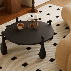 Modern round wooden coffee table with sculptural legs angled view highlighting base