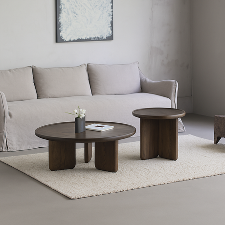 Scandinavian round wooden coffee table with thick legs front view in living room
