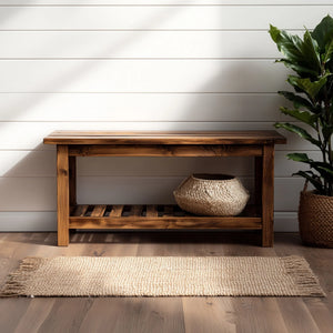 Simple wooden entryway bench with lower storage shelf placed against wall with plant decor
