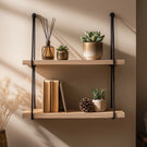 Wooden wall shelf with black rope suspension front view on neutral wall